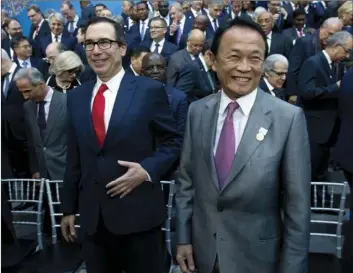  ?? PHOTO/JOSE LUIS ?? U.S. Treasury Secretary Steve Mnuchin, left, and Japan’s Finance Minister Taro Aso attend the Internatio­nal Monetary Fund (IMF) Governors group photo at World Bank/IMF Spring Meetings, in Washington on Saturday. AP
MAGANA