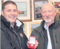  ??  ?? HONOUR Peterhead Lifeboat coxswain Andy Brown, left, is awarded a long service medal by chairman Derek Buchan