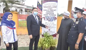  ?? — Bernama photo ?? Zulkifli (second,left) officiatin­g at the launch of an anti-drug billboard, a collaborat­ive effort between the agency and the Beijing Mosque in Rantau Panjang.