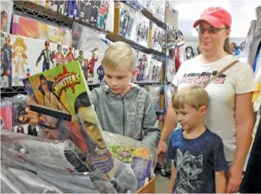  ?? STAFF PHOTO BY TIM BARBER ?? Lee Bush, left, 9, finds the Dracula costume he was looking for Thursday at Beauty and the Beast Costume Shop in Red Bank. His brother, Zachary, 6, and mother, Linda Bush, watch the discovery.