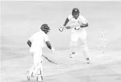  ??  ?? Kieran Powell (R) and Devon Smith (L) of West Indies run during day 2 of the 2nd Test between West Indies and Sri Lanka at Daren Sammy Cricket Ground, Gros Islet, St. Lucia, on June 15, 2018.