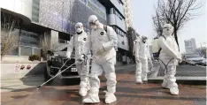  ?? | AP ?? WORKERS wearing protective gears spray disinfecta­nt against the coronaviru­s in front of a church in Daegu, South Korea, yesterday.