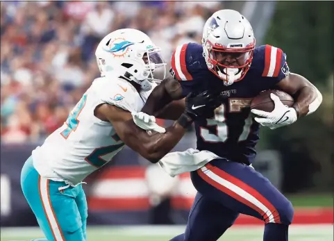  ?? Winslow Townson / Associated Press ?? Patriots running back Damien Harris (37) tries to break free from Dolphins cornerback Byron Jones (24) on Sunday in Foxborough, Mass.