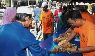  ??  ?? Sharing is caring: About 1,000 villagers of Seberang Perak and Tongkang Yard area were seen queueing up to get their 600g of sacrificia­l meat on the first day of Hari Raya Haji at Masjid Al-ihsan, Seberang Perak in Alor Setar,