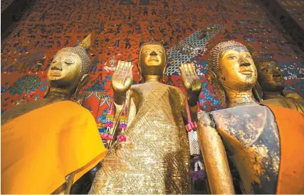  ?? Gettyimage­sbank ?? ◄ Buddhist statues and a colored glass mosaic at Wat Xieng Thong, the Temple of the Golden City, in the UNESCO World Heritage-designated town of Luang Prabang, Laos.