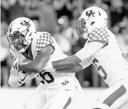  ?? TODD BENNETT/GETTY IMAGES ?? Kentucky quarterbac­k Stephen Johnson (15) and running back Benny Snell Jr. combined for 176 rushing yards in the Wildcats’ upset win over South Carolina.