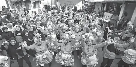  ?? GALIH COKRO/JAWA POS ?? GEMBIRA BERSAMA: Peserta lomba yel-yel asyik joget bersama saat hiburan musik dalam road show SGC di Jalan Kelasi, Krembangan Utara, kemarin.