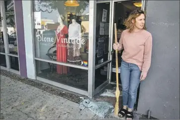  ?? Irfan Khan Los Angeles Times ?? AMY JORDAN sweeps glass Friday after her Burbank boutique, Slone Vintage, was hit by smash-and-grab burglars. Such incidents recently are not indicative of a citywide surge in property crime, LAPD data show.