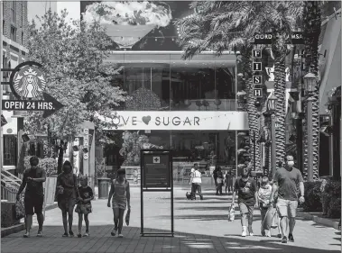  ?? JOE BUGLEWICZ/BLOOMBERG ?? Shoppers walk along the Linq Promenade in Las Vegas last month.