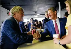  ?? ARVIN TEMKAR/ARVIN.TEMKAR@AJC.COM ?? Gov. Brian Kemp (center) greets Charles Jay, owner of the White Diamond Grill in Bonaire, before signing a $1 billion tax cut bill. The setting was strategic — David Perdue, Kemp’s rival for the GOP nomination, eats there often.