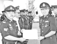  ??  ?? Haris (right) presenting a certificat­e of appreciati­on to a police personnel at the event yesterday.