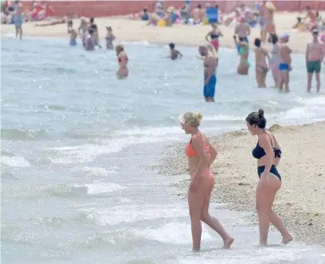  ?? JIM MICHAUD PHOTOS / BOSTON HERALD ?? HOW ABOUT A SWIM? People flock to the city’s Carson Beach, above and far right, to escape the hot and humid weather on Sunday.