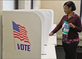  ?? BILL LACKEY/STAFF ?? Camille Hall from the Clark County Board of Elections wipes down voting booths for early voters Wednesday. Local boards of elections are taking steps to make sure polling places are clean and virus free.