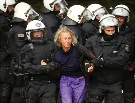  ?? Foto: dpa/David Young ?? Am Montag im Hambacher Forst: Eine Anti-Kohle-Aktivistin wird abgeführt.