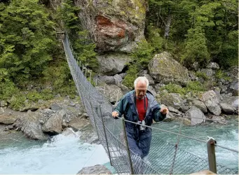  ??  ?? Right: Bob Watson walking over the Lee Creek swing bridge in the Rainbow valley Marlboroug­h. Photo by Rebecca Bowater, Atawhai, Nelson.