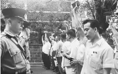  ?? — AFP photo ?? In this photograph received from the South China Morning Post (SCMP) archive on May 2, 2017 and taken on May 16, 1967, protesters (right) wave the Little Red Book ‘The Quotations from Chairman Mao Zedong’ in front of police outside the South Kowloon...