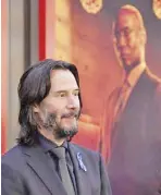  ?? – AP PHOTO ?? Keanu Reeves on the late Lance Reddick (photo in background): 'He had a dignity to him and a presence.'