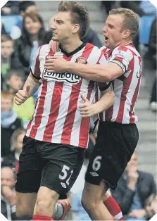  ??  ?? Lee Cattermole jumps on Nicklas Bendtner to celebrate Sunderland going 2-1 up at Manchester City.
