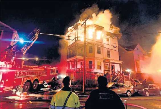  ?? JIM MICHAUD / BOSTON HERALD ?? UP IN FLAMES: Lynn firefighte­rs battle a fire on Grover Street last night in Lynn. All occupants of the three-story residentia­l building were accounted for with no injuries.