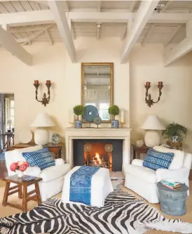  ?? Roger Davies ?? Ornate sconces, patterned pillows and an animal print rug accent the living room of Suzanne Tucker and Timothy Mark’s weekend house in Montecito.