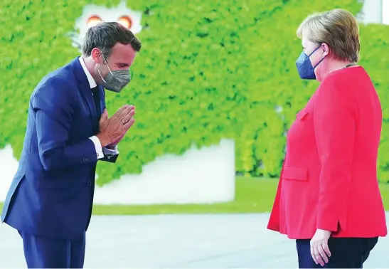  ?? EFE ?? El presidente francés, Emmanuel Macron, saluda a la canciller alemana, Angela Merkel, a su llegada ayer a Berlín