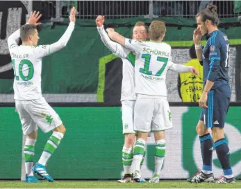  ?? FOTO: DPA ?? Freudentän­ze in der Volkswagen Arena: Wolfsburgs Maximilian Arnold ( Zweiter von links) jubelt über sein Tor zum 2: 0 mit den Teamkolleg­en Julian Draxler ( links) und André Schürrle. Reals Gareth Bale staunt.