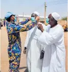  ?? Photo / AP ?? A peacekeepe­r hands out masks and hand sanitiser in the streets of El Fasher in North Darfur.