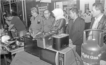  ??  ?? This picture taken on July 22 shows Indonesian officials standing next to home appliances seized from inmates at the Sukamiskin jail in Bandung. — AFP photo