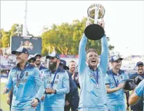  ?? ALASTAIR GRANT/ASSOCIATED PRESS ?? England’s Jos Buttler holds the trophy as he celebrates after winning the Cricket World Cup against New Zealand on Sunday at Lord’s cricket ground in London. England won after a super over after the scores ended tied after 50 overs each.