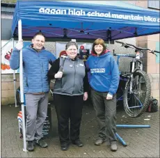  ?? 01_B11CCF03 ?? Co-op manager Liz McLean gives Robert McNeice and Kim Toogood of the mountain bike club a helping hand.