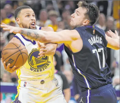  ?? Jed Jacobsohn The Associated Press ?? Warriors guard Stephen Curry scoops up a shot against Mavericks guard Luka Doncic during Golden State’s 126-117 victory in Friday’s Game 2 of the Western Conference finals.
