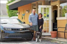  ?? CARRIE GARLAND — THE NEWS-HERALD ?? Eddie Francis Jr. and wife Rennada have run Kirtland Car Company for nearly 30 years. With them is 16-year-old Chow Chow mix Mia, a customer favorite.