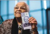  ?? Associated Press photo ?? Wanda Robson, sister of Viola Desmond, holds the new $10 bank note featuring Desmond during a press conference in Halifax on Thursday.