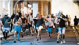  ?? CARLOS GIUSTI/AP ?? Protesters run from police who dispensed tear gas during clashes Monday in San Juan.