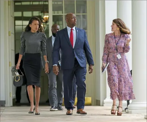  ?? Evan Vucci/Associated Press ?? Sen. Tim Scott, R-S.C., center, arrives for an event on police reform Tuesday in the Rose Garden of the White House in Washington. Family members who had loved ones die in encounters with police met with President Donald Trump, then Mr. Scott about police brutality and desired reforms.