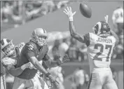  ??  ?? MICAH KISER, left, pressures Raiders quarterbac­k EJ Manuel as Isaiah Johnson def lects a pass.