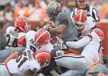  ?? File, Curtis Compton /Atlanta Journal-Constituti­on via AP ?? Georgia defenders gang tackle Tennessee running back John Kelly during a recent game. The defensive squads at Alabama, Georgia and Auburn are among the best in the country and have them poised for a run at the playoffs.