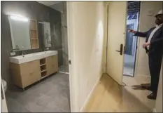  ?? AP PHOTO/BEBETO MATTHEWS ?? Malek Hajar, senior project manager at the Vanbarton Group, shows a bathroom inside a model apartment while touring a high rise undergoing conversion from commercial to residentia­l apartments, Tuesday, April 11, 2023, in New York.