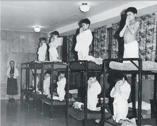  ?? QMI AGENCY ?? Aboriginal children pray at a residentia­l school in this undated photo. Professor Payam Akhavan says the claim of cultural genocide of aboriginal­s threatens to leave Canadians unable to ‘fathom the depth of human suffering.’ He adds that the phrase also threatens to leave Canadians ‘lost in abstractio­ns.’