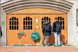  ?? Bill Pugliano/Getty Images/TNS ?? People visit a memorial at Berkey Hall on the day that Michigan State University students return to classes Feb. 20 for the first time since the Feb. 13 mass shooting there in East Lansing, Mich. The gunman shot eight students on the campus of MSU, killing 3 of them, one of them at Berkey Hall.