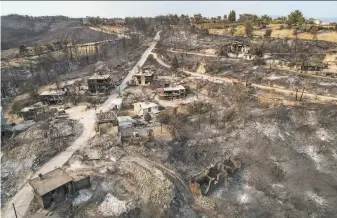  ?? Associated Press ?? Only the shells of homes remain after a wildfire ripped through the village of Kalemli in Antalya province. Fed by strong winds and scorching heat, the fires have left eight people dead.