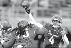  ?? Arkansas Democrat-Gazette/THOMAS METTHE ?? (4) passes over defensive lineman Deion Malone during Saturday’s Red-White game at War Memorial Stadium in Little Rock. Storey and teammate Cole Kelley each passed for 126 yards and one touchdown.