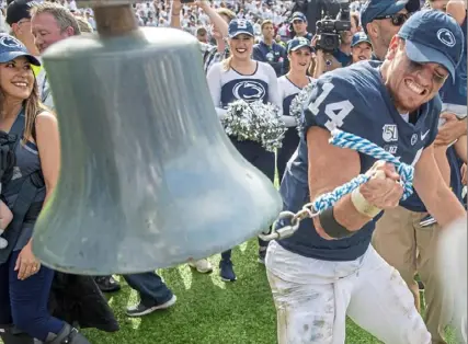  ?? Steph Chambers/Post-Gazette ?? Penn State quarterbac­k Sean Clifford rings the victory bell after beating Pitt, 17-10, on Saturday at Beaver Stadium in University Park in the final game — for now — of a storied in-state rivalry.