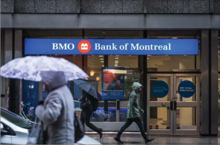  ?? AARON VINCENT ELKAIM, THE CANADIAN PRESS ?? People walk by a Bank of Montreal branch in Toronto’s financial district on Tuesday.