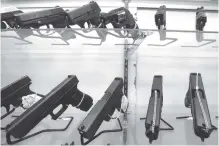  ?? ASSOCIATED PRESS FILE PHOTO ?? Guns are displayed at a gun store on June 29, 2016, in Miami.