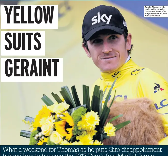  ??  ?? Geraint Thomas on the podium after retaining the leaders’ jersey after stage two of the Tour de France yesterday
