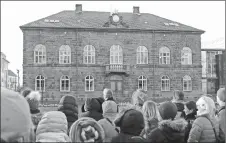  ?? AP PHOTO ?? People look at the Icelandic parliament, the Althing, in Reykjavik. Icelandic companies are getting ready to comply with a new law requiring them to prove their pay practices don’t discrimina­te against women.