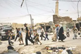  ?? ASSOCIATED PRESS FILE PHOTO ?? Residents walk past the crooked minaret in a busy market area in Mosul, Iraq, in 2009. Iraq’s ministry of defense said Islamic State militants destroyed the al-Nuri mosque in Mosul and the adjacent iconic leaning minaret when fighters detonated...