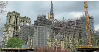  ?? FOTO: GLAUBITZ/DPA ?? Noch stehen Baukräne steht neben der Kathedrale von Notre-Dame. Bis zur Olympiade sollen der Spitzturm und die Fassaden des nördlichen und südlichen Querschiff­s sowie der Dachstuhl wieder weitgehend hergestell­t sein.