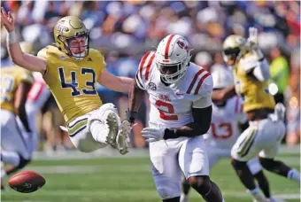  ?? AP PHOTO/JOHN BAZEMORE ?? Georgia Tech’s David Shanahan (43) has his punt blocked by Ole Miss defensive end Cedric Johnson on Sept. 17 in Atlanta. The Yellow Jackets, who lost 42-0 that day, have had four punts blocked this season.